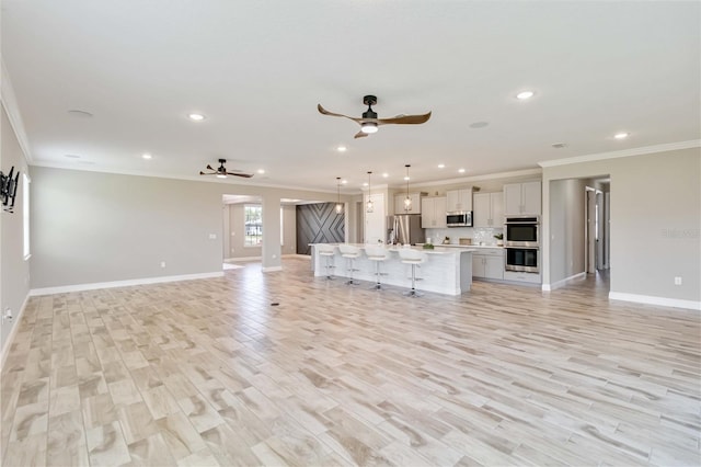 unfurnished living room featuring recessed lighting, a ceiling fan, and crown molding