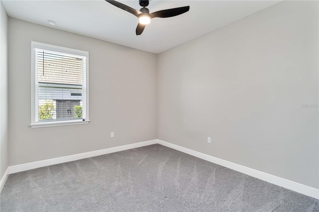 carpeted spare room featuring plenty of natural light, ceiling fan, and baseboards