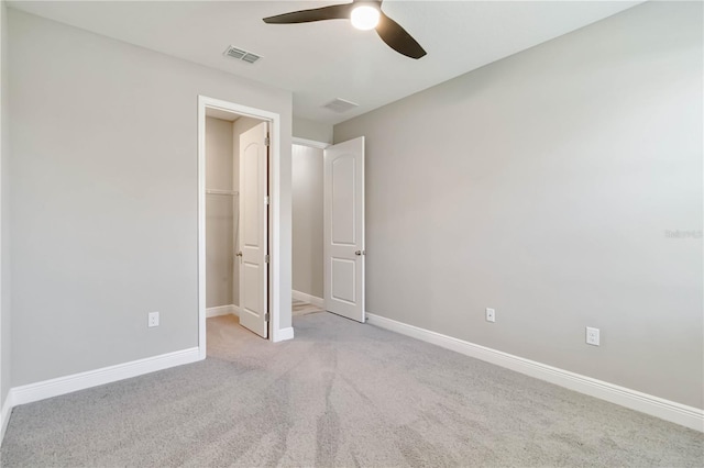 unfurnished bedroom with carpet flooring, visible vents, baseboards, and a spacious closet