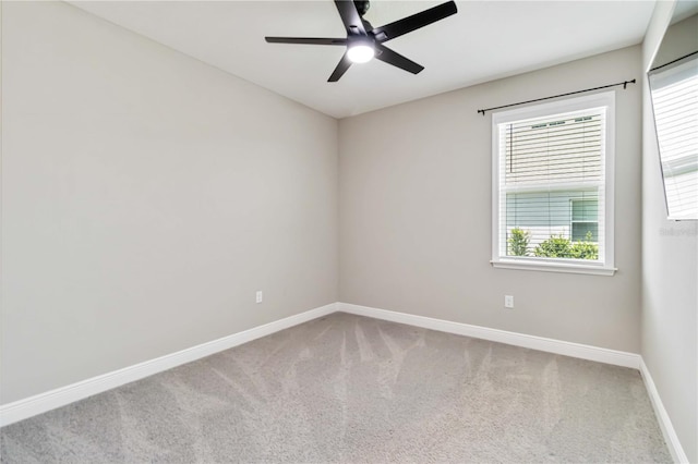 carpeted empty room with ceiling fan and baseboards