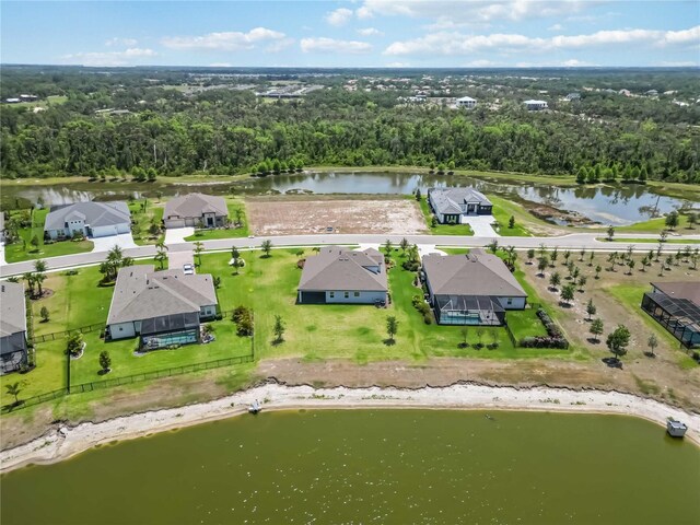 birds eye view of property with a water view, a view of trees, and a residential view