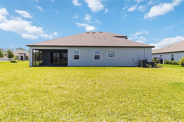 back of house with a lawn, central AC unit, stucco siding, and a sunroom
