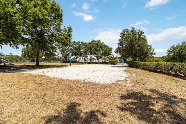 view of home's community featuring a lawn, playground community, and volleyball court