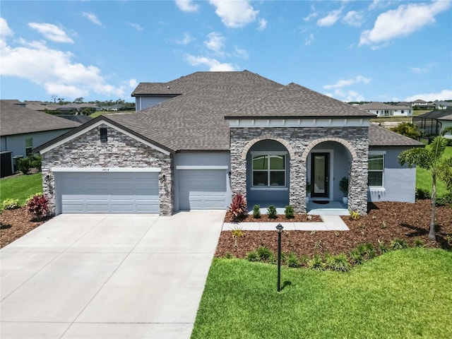 14914 15th St E, Parrish, FL 34219 - french country style house with roof with shingles, a garage, and stone siding