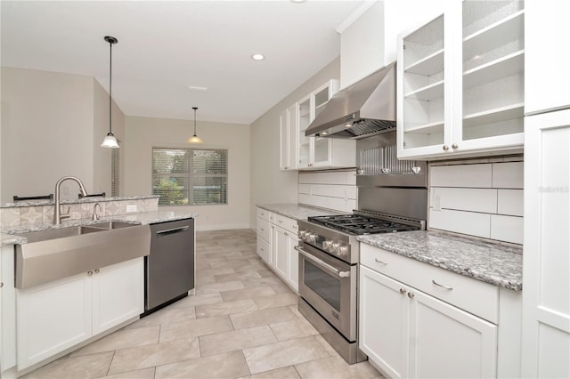 kitchen with range hood, stainless steel appliances, white cabinetry, and a sink