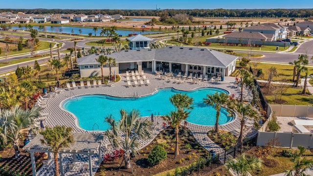 pool featuring a patio area, a fenced backyard, a residential view, and a water view