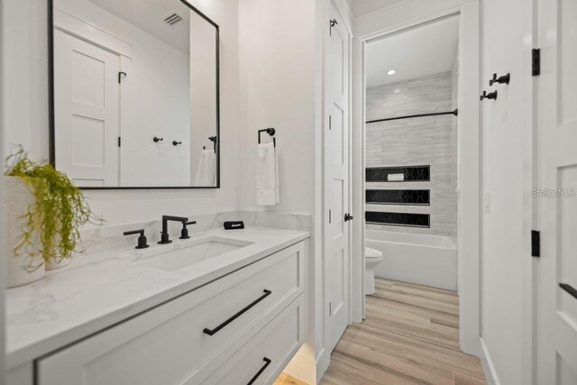 89 Avenida Messina, Sarasota, FL 34242 - bathroom with wood finished floors, visible vents, toilet, vanity, and  shower combination