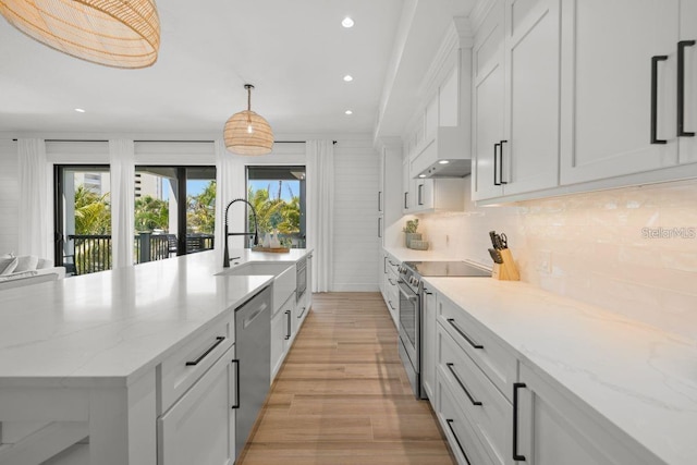 89 Avenida Messina, Sarasota, FL 34242 - kitchen featuring light wood finished floors, a healthy amount of sunlight, appliances with stainless steel finishes, and decorative backsplash