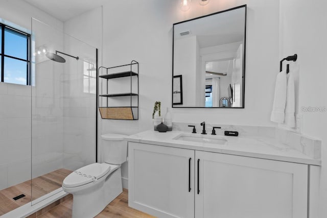 89 Avenida Messina, Sarasota, FL 34242 - bathroom featuring a tile shower, wood finished floors, toilet, and vanity