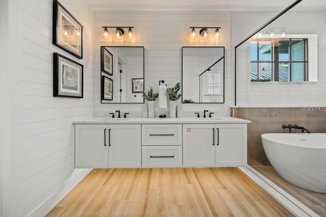 89 Avenida Messina, Sarasota, FL 34242 - full bath with a freestanding tub, wood finished floors, double vanity, and a sink
