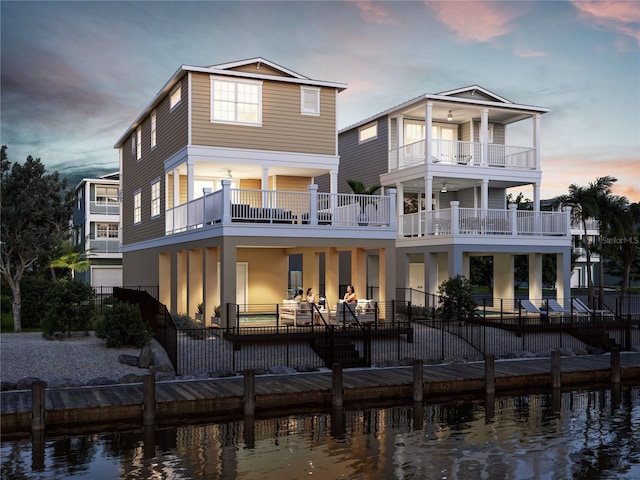 4206 Saltwater Pearl Way, Cortez, FL 34215 - back of property at dusk featuring fence, a water view, a patio, and a balcony