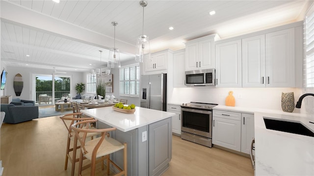 4206 Saltwater Pearl Way, Cortez, FL 34215 - kitchen with stainless steel appliances, a sink, light wood-type flooring, a kitchen island, and wood ceiling
