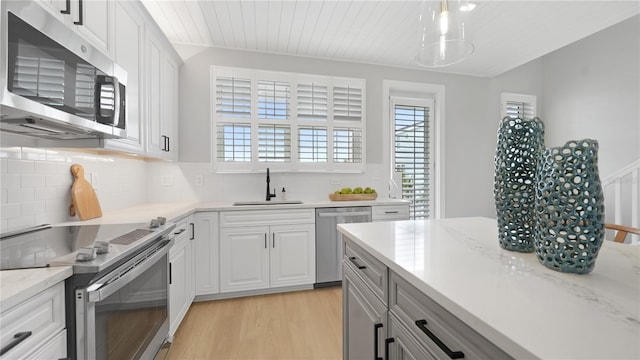 4206 Saltwater Pearl Way, Cortez, FL 34215 - kitchen with a sink, decorative backsplash, stainless steel appliances, light wood finished floors, and white cabinets