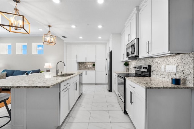 kitchen with a notable chandelier, recessed lighting, marble finish floor, a sink, and appliances with stainless steel finishes