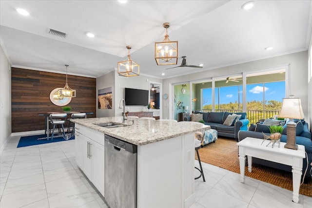 kitchen featuring marble finish floor, wood walls, a sink, and stainless steel dishwasher