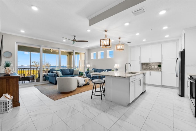 kitchen featuring recessed lighting, ceiling fan, visible vents, a sink, and open floor plan