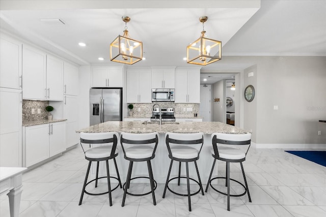 kitchen with appliances with stainless steel finishes, decorative backsplash, marble finish floor, and a notable chandelier