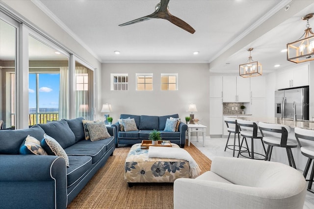 living room with ornamental molding, ceiling fan with notable chandelier, and recessed lighting