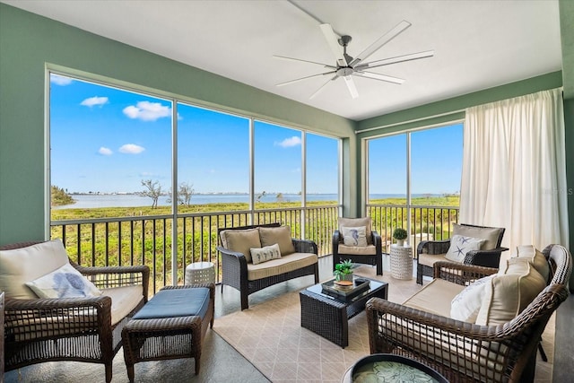 sunroom with a water view, an outdoor living space, and a ceiling fan