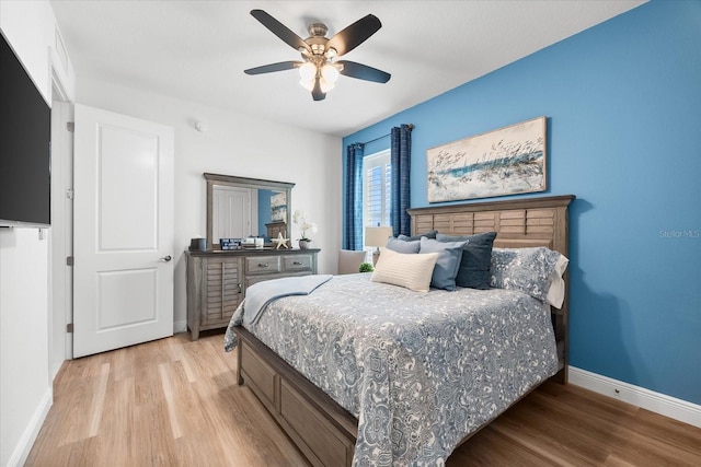 bedroom with light wood-type flooring, baseboards, and a ceiling fan