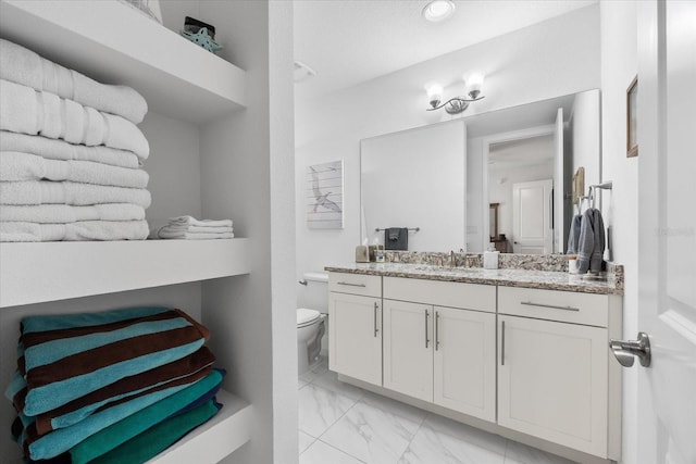 bathroom featuring toilet, marble finish floor, vanity, and recessed lighting