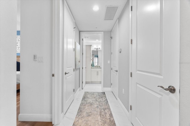 corridor with baseboards and visible vents