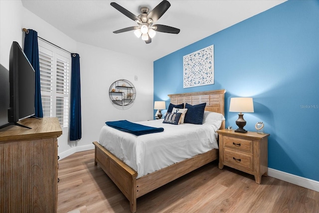 bedroom with wood finished floors, baseboards, and a ceiling fan