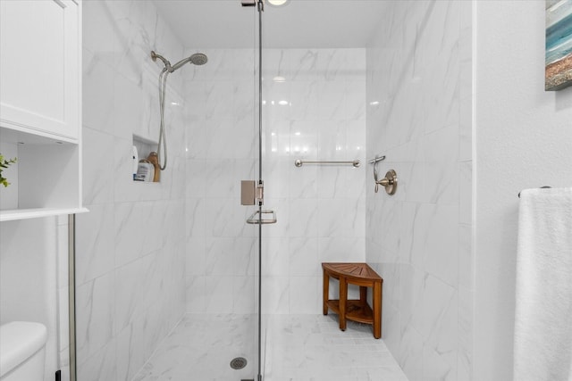 bathroom with toilet and a shower stall