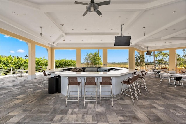 view of patio / terrace with a ceiling fan, outdoor wet bar, and fence