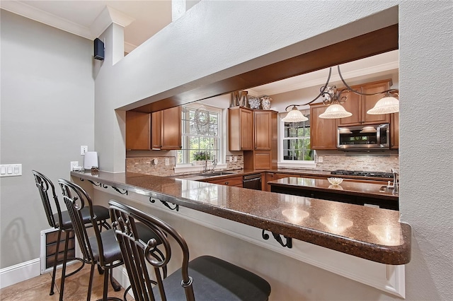 1788 Palm View Rd, Sarasota, FL 34240 - kitchen featuring dark countertops, a breakfast bar area, stainless steel microwave, tasteful backsplash, and ornamental molding