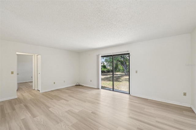 unfurnished room featuring light wood-style floors, a textured ceiling, and baseboards