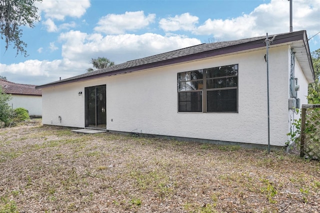 rear view of house with stucco siding