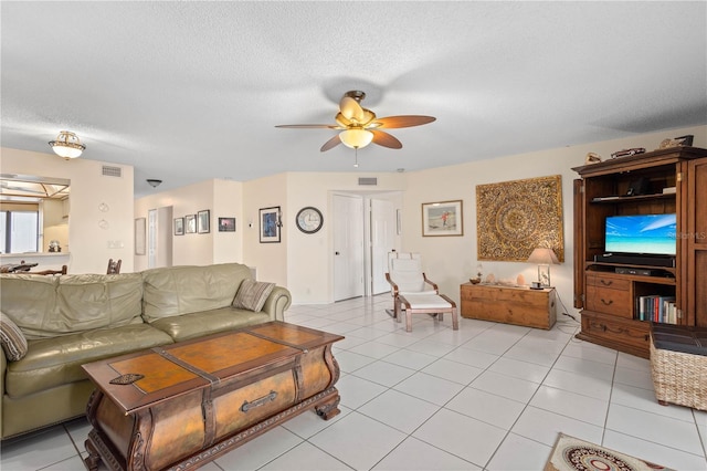 6780 Schooner Bay Cir Unit 6780, Sarasota, FL 34231 - living room featuring a ceiling fan, a textured ceiling, visible vents, and light tile patterned floors