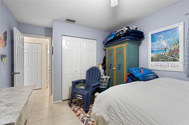 6780 Schooner Bay Cir Unit 6780, Sarasota, FL 34231 - bedroom featuring visible vents, light tile patterned flooring, a closet, a textured ceiling, and ceiling fan