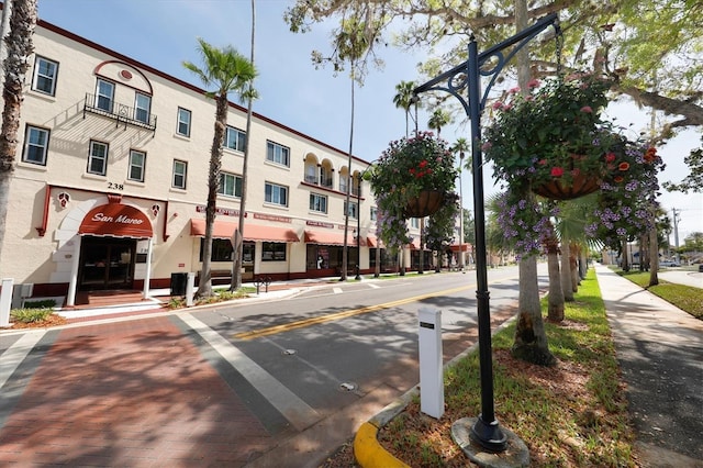 view of road with street lights, sidewalks, and curbs
