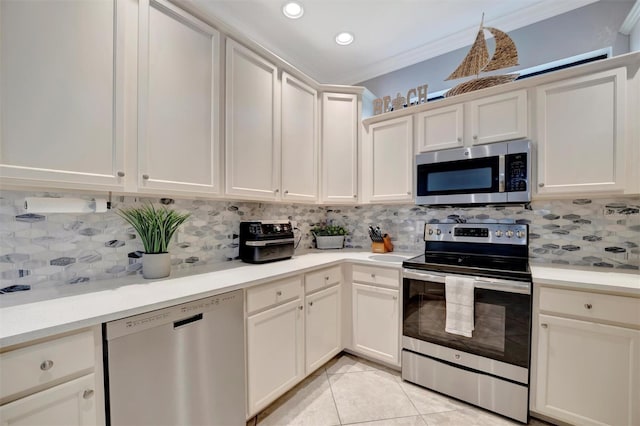 kitchen with stainless steel appliances, light countertops, decorative backsplash, and crown molding