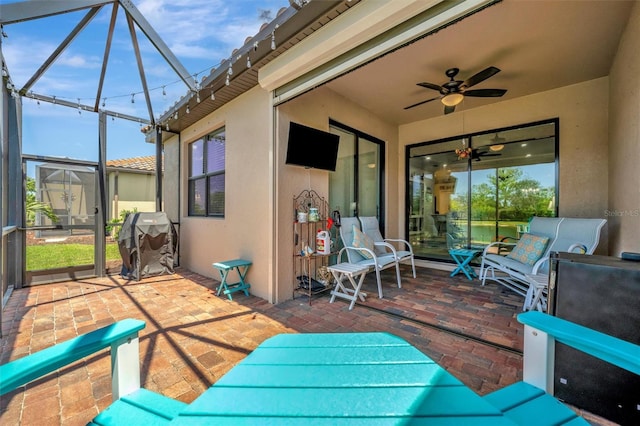 view of patio featuring a ceiling fan, a lanai, and a grill
