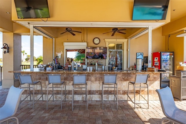 view of patio featuring a bar and ceiling fan
