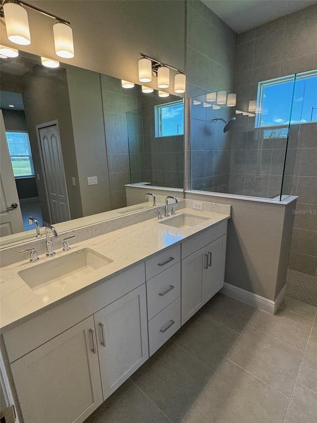 full bathroom featuring double vanity, walk in shower, tile patterned floors, and a sink
