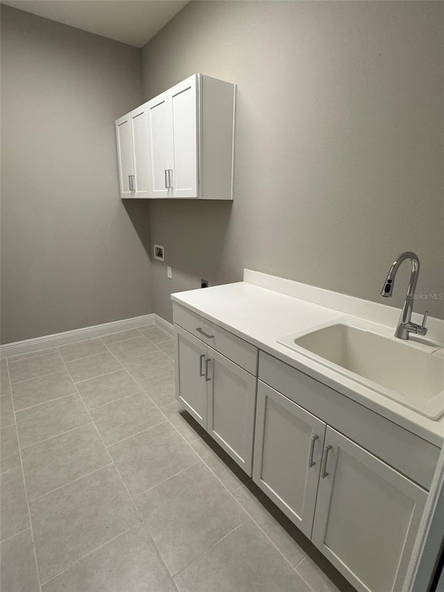 laundry room with hookup for an electric dryer, light tile patterned flooring, a sink, hookup for a washing machine, and cabinet space