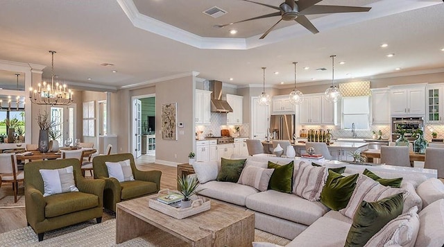 living area featuring recessed lighting, light wood-style flooring, visible vents, and ceiling fan with notable chandelier