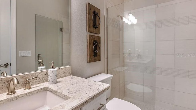 full bath with vanity, toilet, and tiled shower