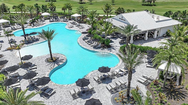 pool featuring view of golf course and a patio area