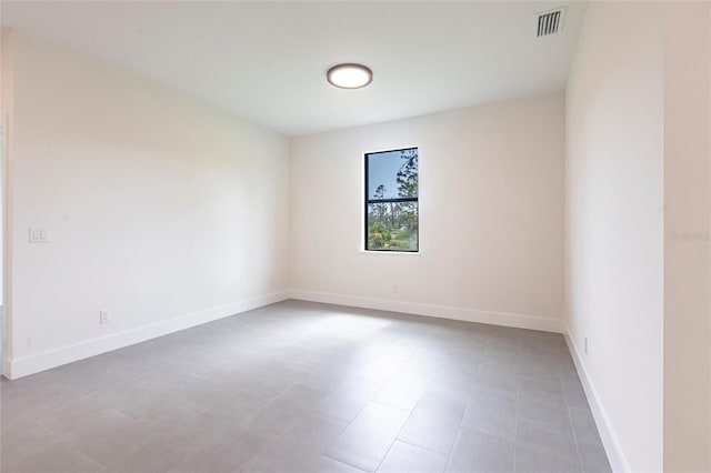 unfurnished room featuring baseboards and light tile patterned flooring