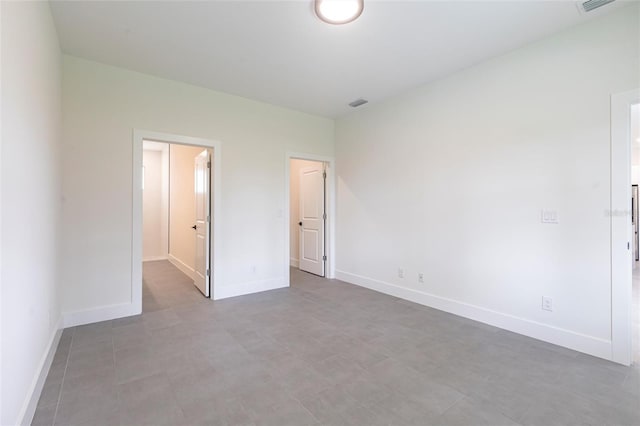 unfurnished bedroom featuring baseboards and a walk in closet