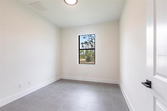 spare room with baseboards and tile patterned floors