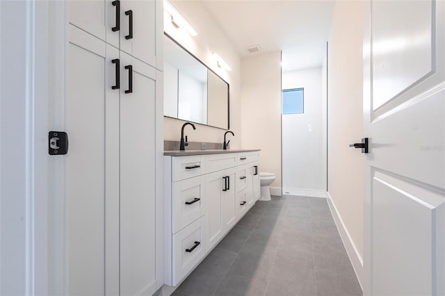 full bath with toilet, double vanity, tile patterned floors, baseboards, and a shower