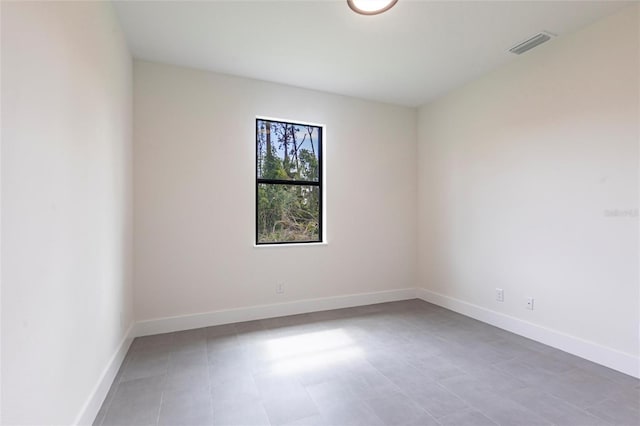 spare room with baseboards and tile patterned floors