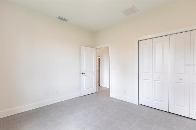unfurnished bedroom with baseboards, a closet, and light tile patterned flooring