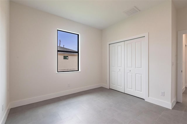 unfurnished bedroom with baseboards and a closet
